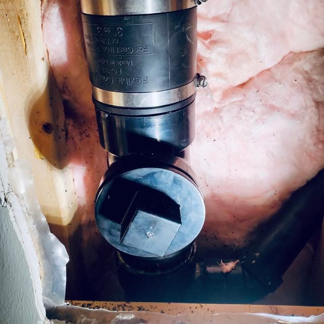 Repaired drain stack joined with a flexible coupling and a new cleanout fitting.