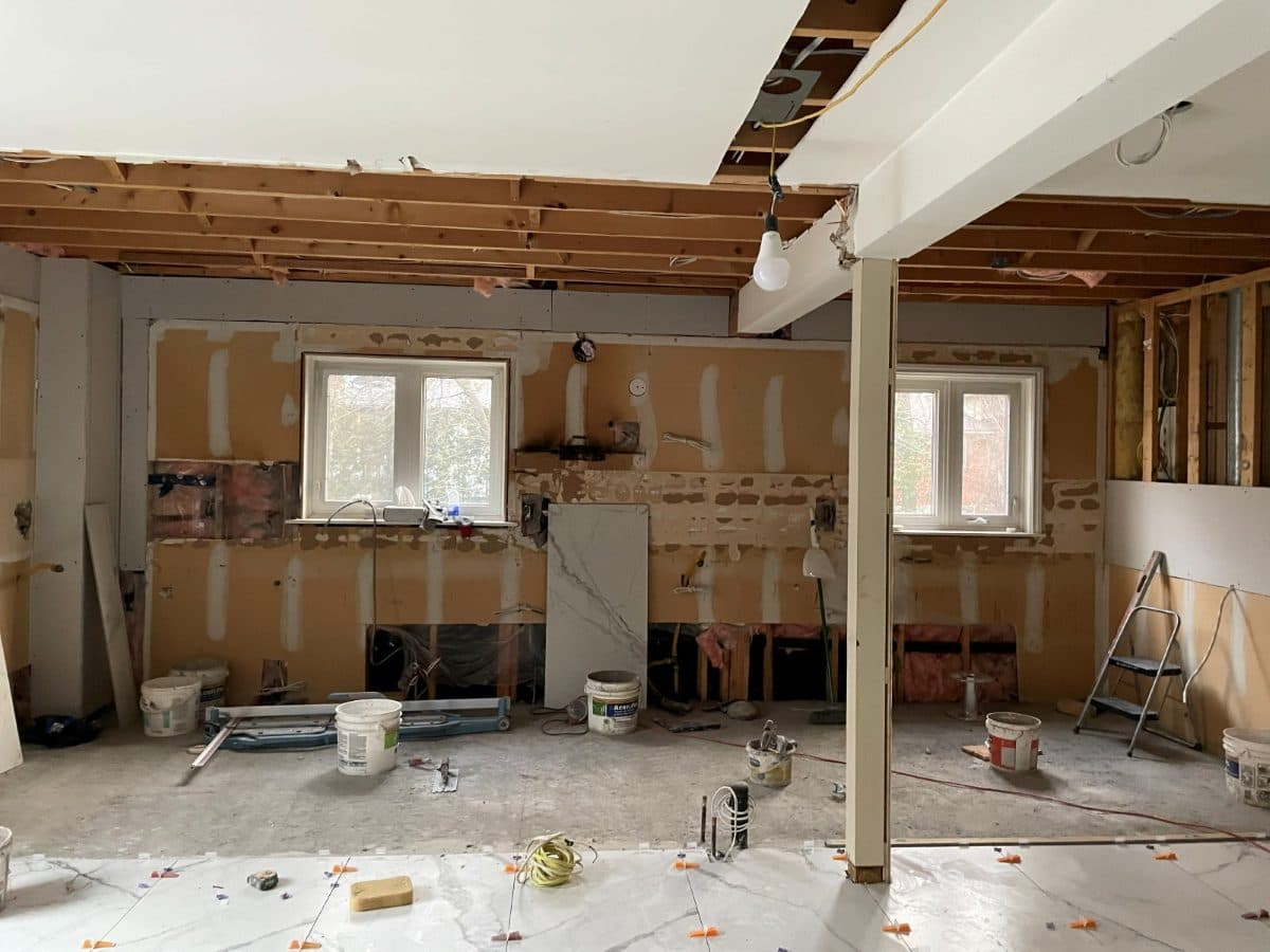 Stripped-back room during renovation with new plumbing runs visible in the open studs.